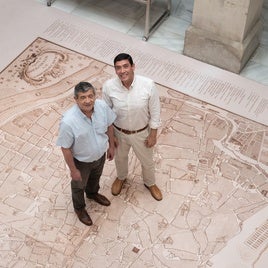 Marcos Fernández y Braulio Vázquez, directores del Archivo Municipal y del Archivo Histórico Provincial, sobre la copia del plano de Sevilla de Olavide, que se muestra en la exposición