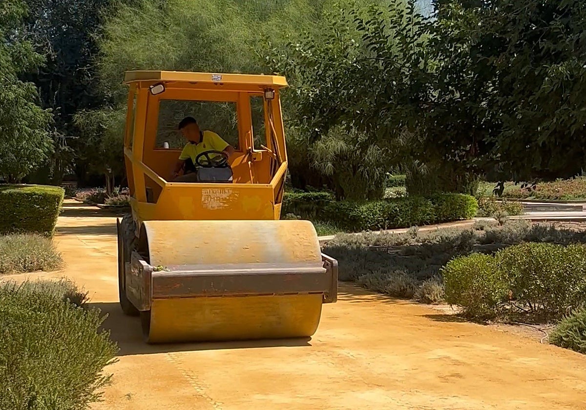 Un operario adecenta uno de los caminos de los Jardines del Guadalquivir