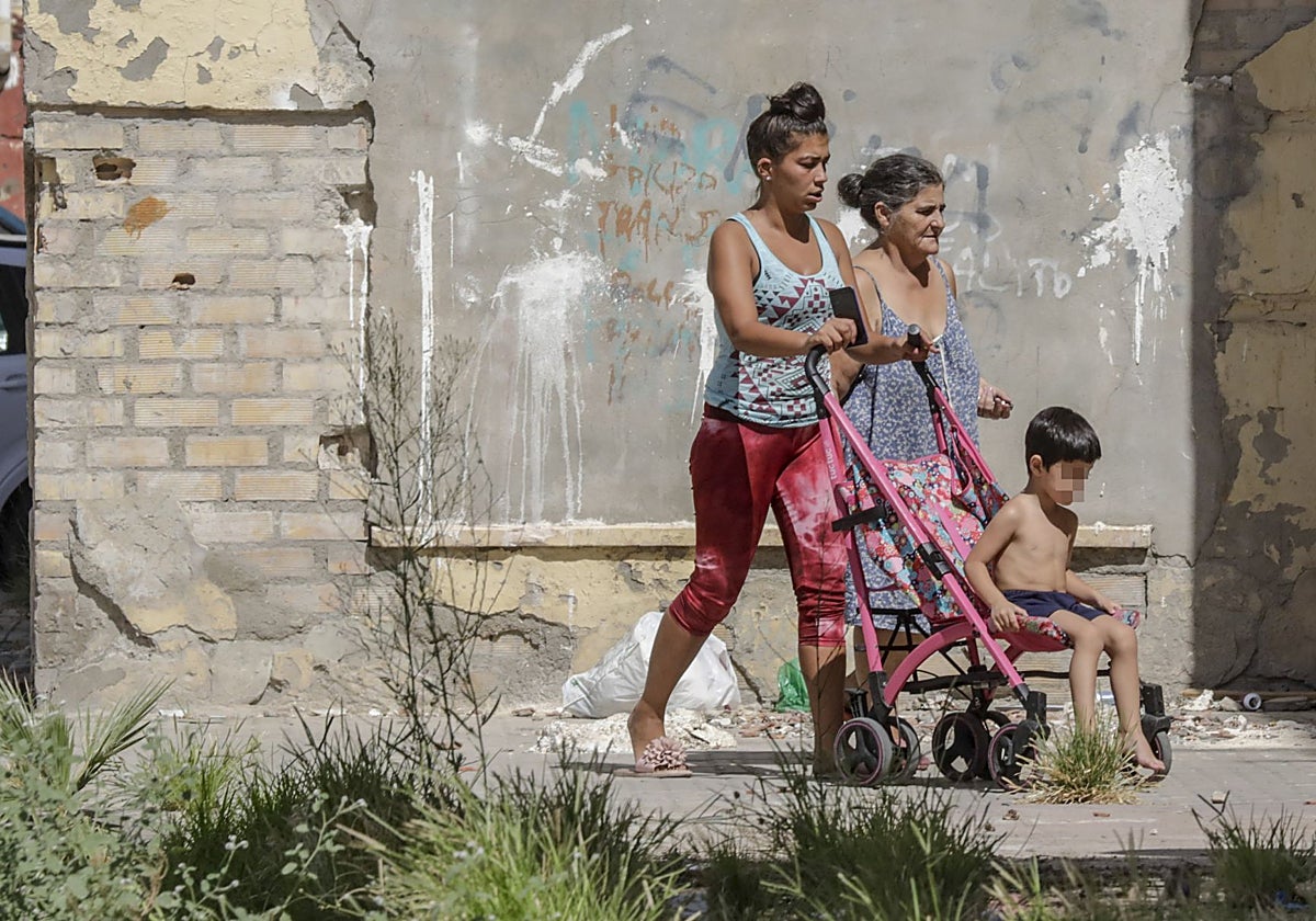 Dos mujeres y un niño transitan por uno de los barrios desfavorecidos de Sevilla