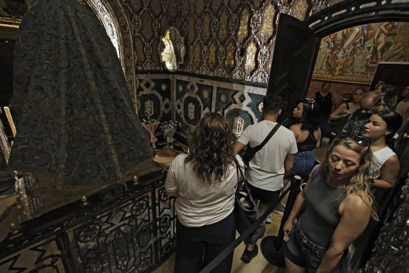 Hermanos y fieles pasan por el camarín de la Macarena antes de ser retirada al culto para su restauración