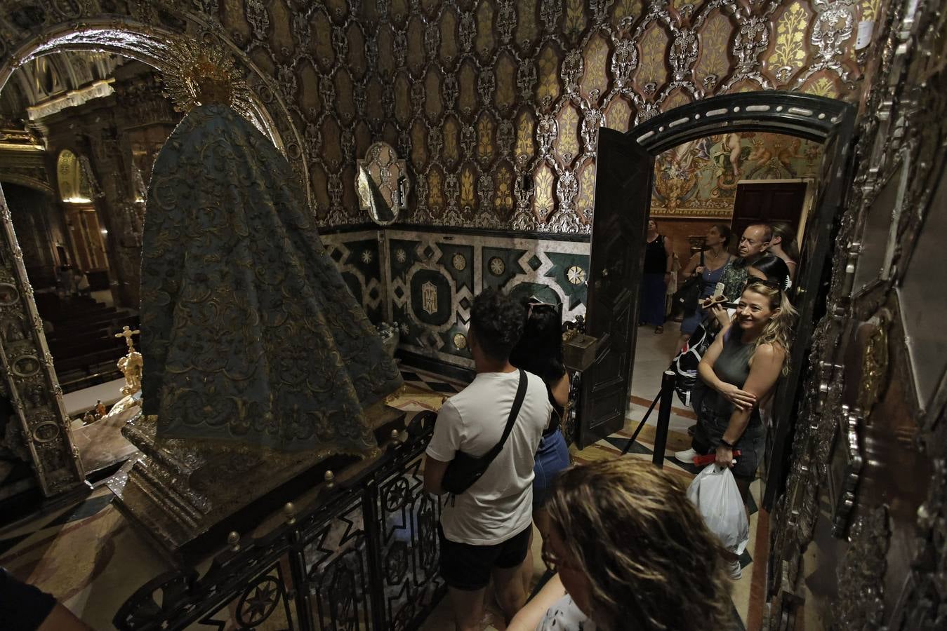 Hermanos y fieles pasan por el camarín de la Macarena antes de ser retirada al culto para su restauración