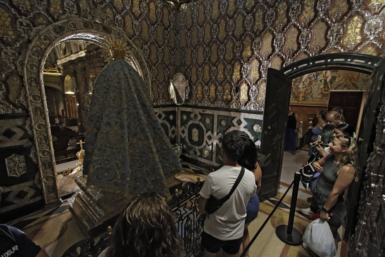 Hermanos y fieles pasan por el camarín de la Macarena antes de ser retirada al culto para su restauración