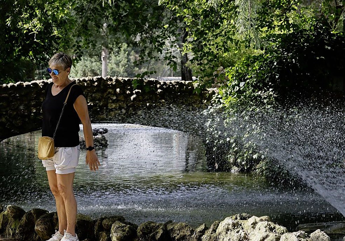 Imagen de una mujer refrescándose en una zona del Parque de María Luisa, en Sevilla