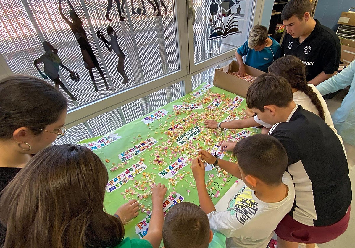 Miembros del grupo joven e infantil de Bendición y Esperanza preparando la alfombra de flores