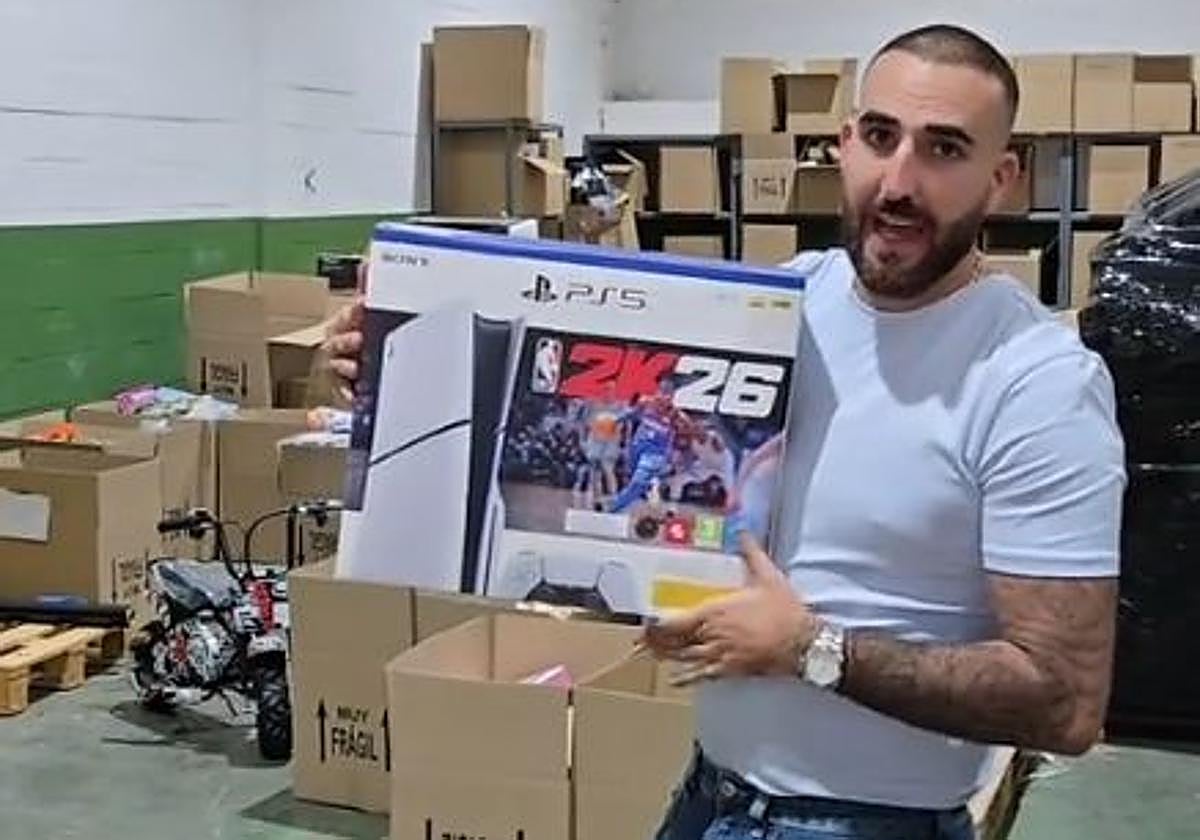 Rafael muestra una Play Station que será sorteada para los primeros que accedan a tienda