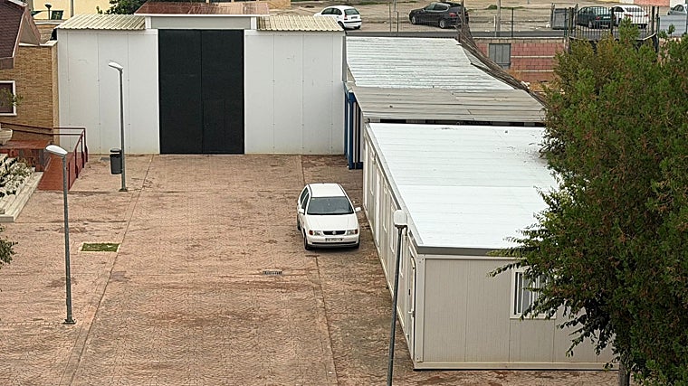 Los 'container' en los que se ven obligados los voluntarios a dar sus clases; en el techo, una valla vencida por los numerosos saltos que se realizan para colarse