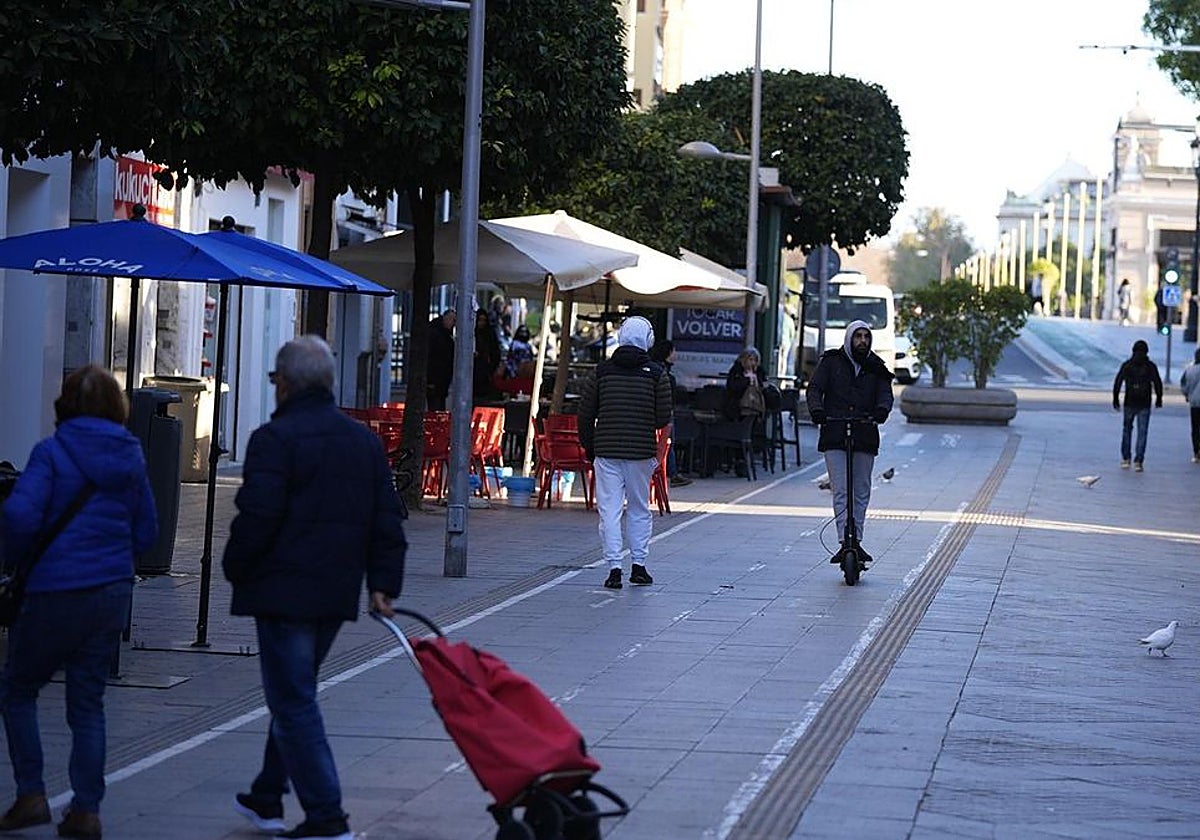 Gente paseando por la calle San Jacinto durante un día de frío otoñal y cielos despejados en Sevilla