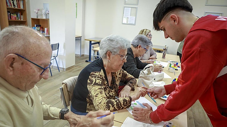 El voluntario Juan María, matriculado en Bellas Artes, atiende a Lola en la Fundación Prodean de Sevilla