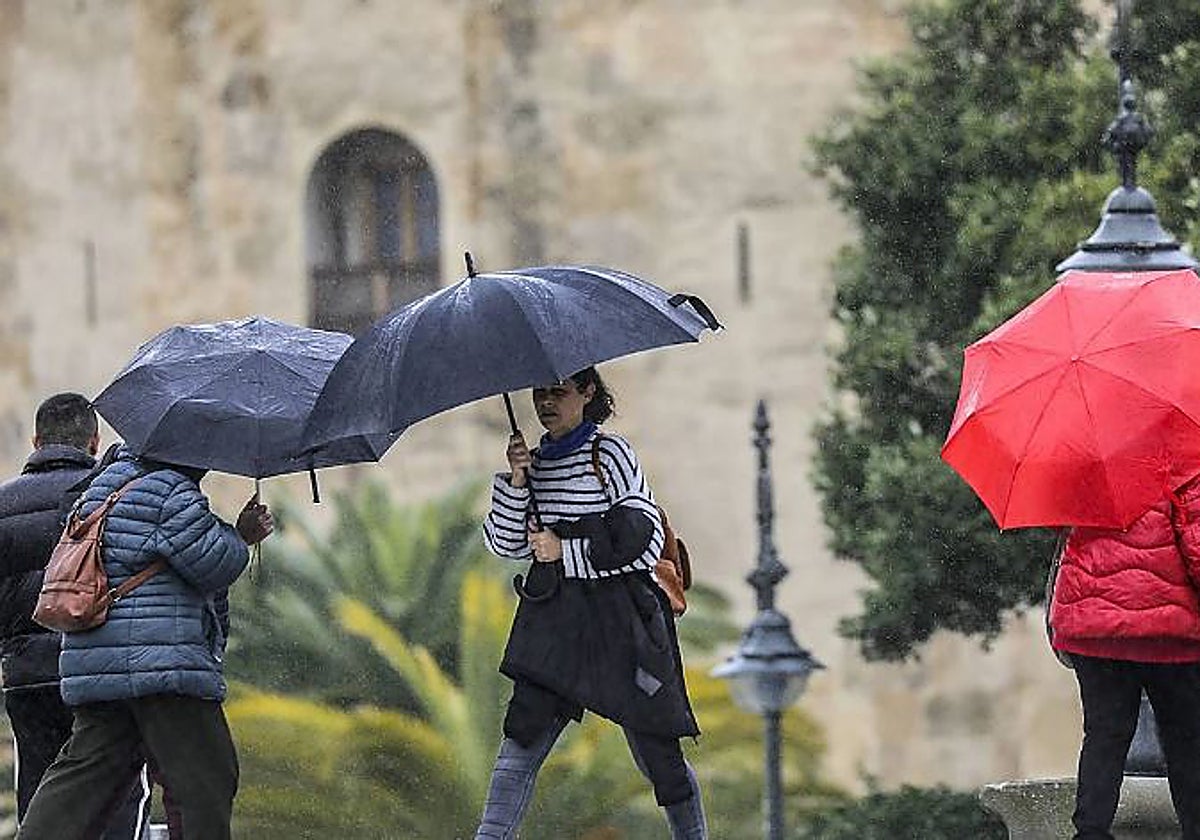 Varias personas se resguardan de la lluvia en Sevilla