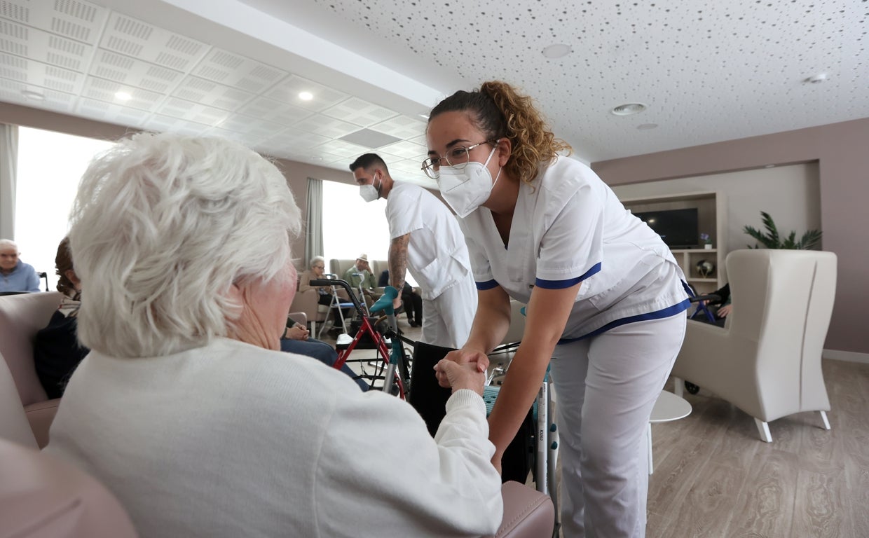 Una trabajadora de una residencia de mayores atiende a una señora