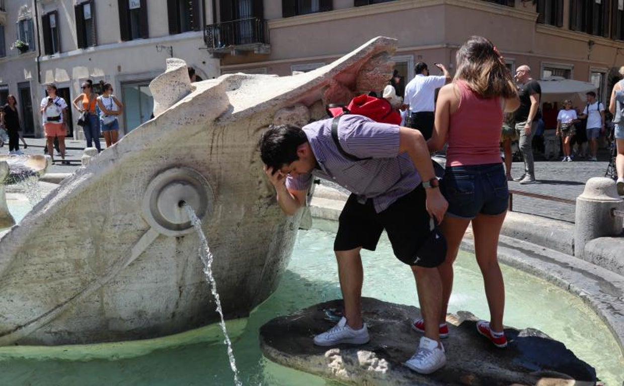 Unos turistas se refrescan estos días en la 'Fontana della Barcaccia' de Bernini en la plaza de España de Roma