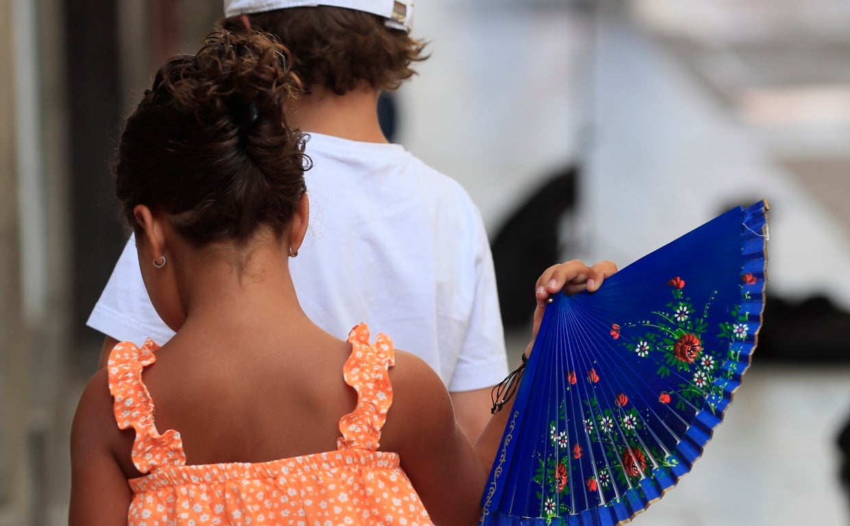 Una niña mitiga el calor con un abanico este jueves en el centro de Madrid