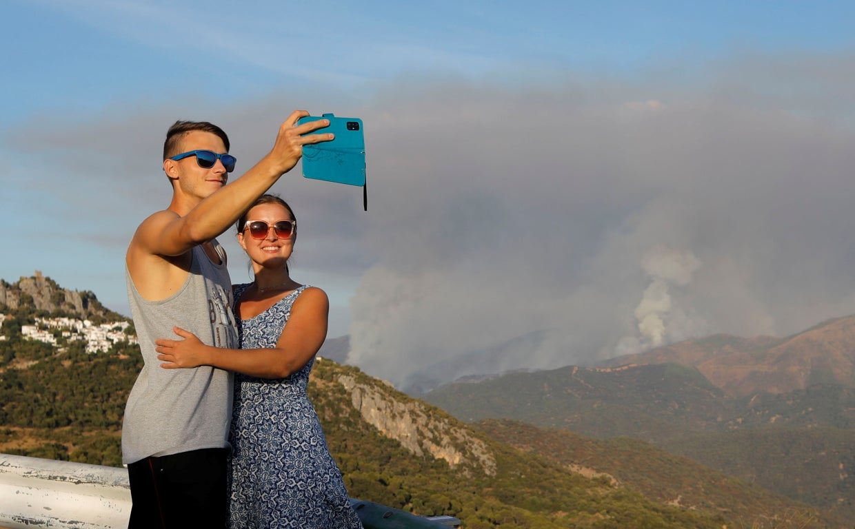 Unos turistas se fotografían ante el incendio de Gaucín, en Málaga, el año pasado