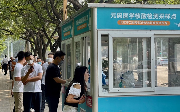 Imagen principal - Los controles PCR son obligatorios en Pekín y otras ciudades cada dos o tres días para poderse mover en transporte público (arriba). El traslado de contactos directos del Covid-19 en autobús, con un conductor con traje de seguridad y de madrugada, ha provocado un accidente que ha causado 27 muertos.