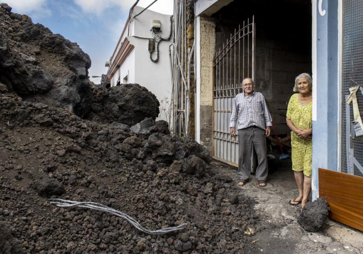 Dos vecinos del barrio de La Laguna con la lava a los pies de su vivienda, un año después de la erupción