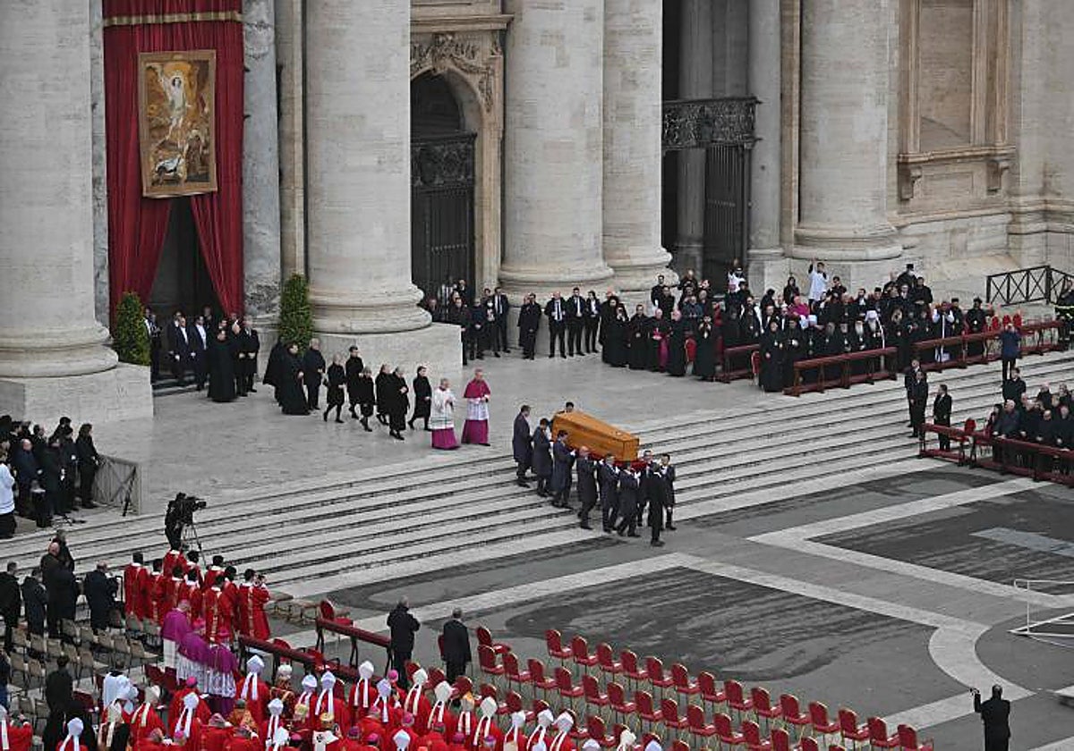 Los sediarios llevan el féretro del Papa emérito junto al altar, antes del inicio de la ceremonia