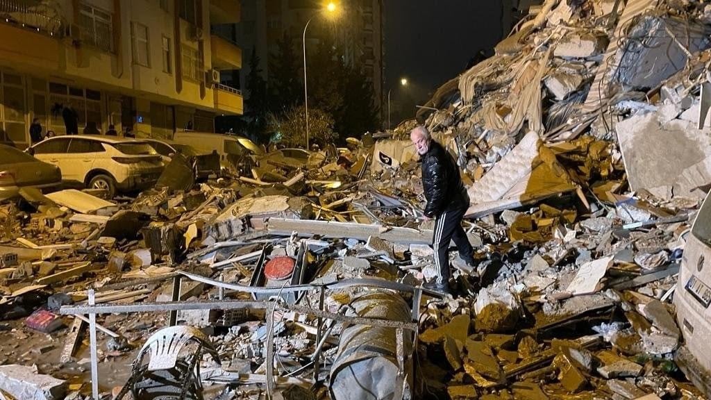 Un hombre busca entre los escombros después del gran terremoto que golpeó cerca de Nurdagi, en el sureste de Turquía