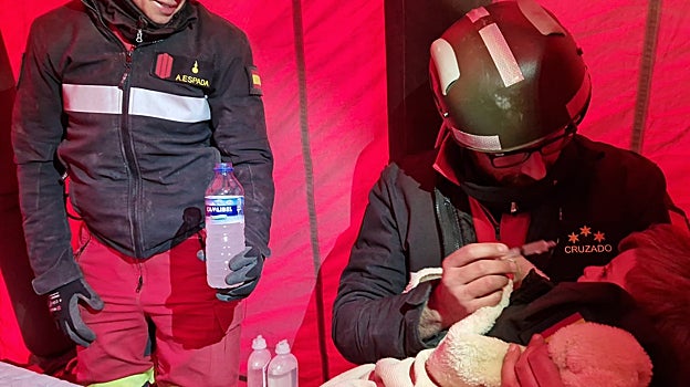 Un miembro de la UME hidrata al pequeño Muslim, tras salvarle de los escombros