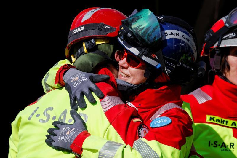 Miembros del equipo del dispositivo de rescate alemán se abrazan tras salvar a una de las víctimas