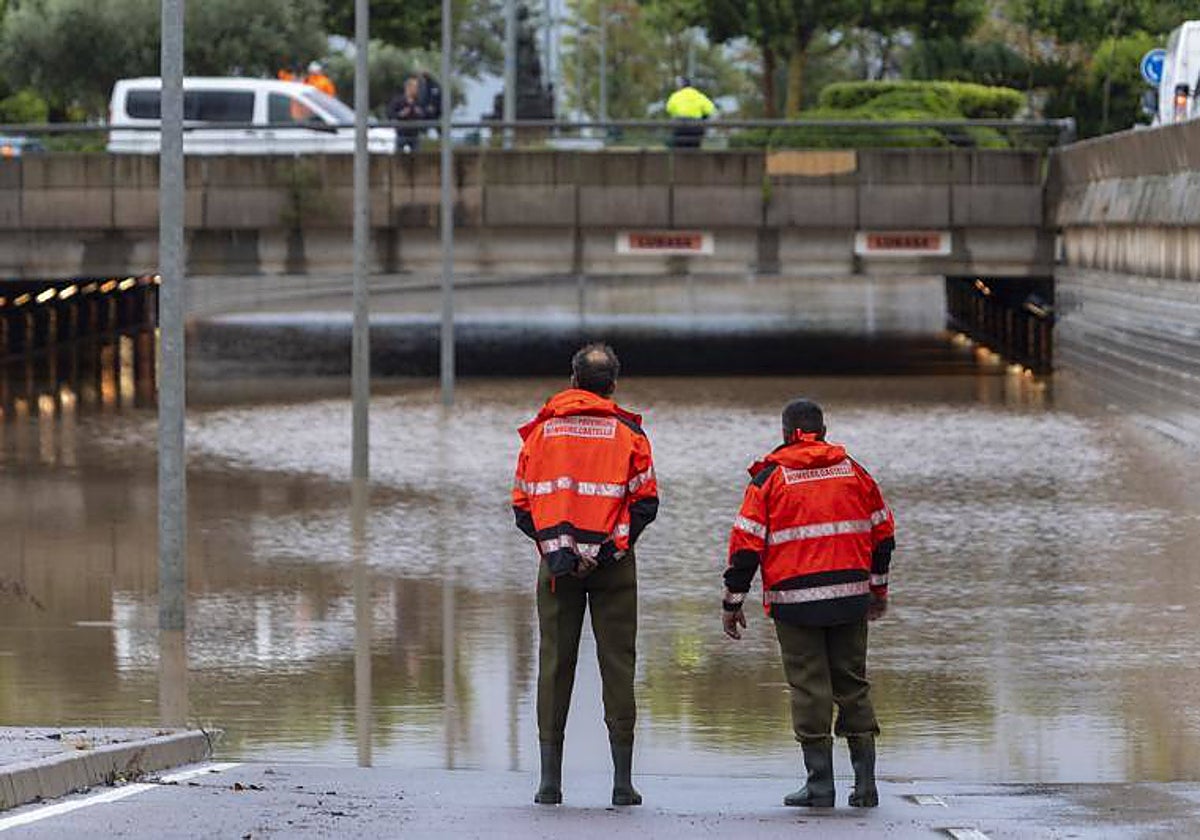Dos bomberos frente a una carretera inundada en Castellón, Valencia