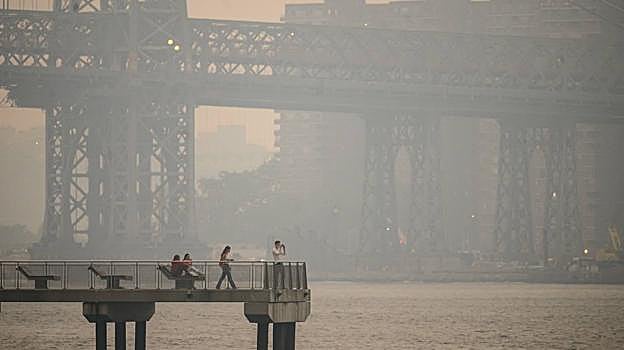 Varias personas observando el humo que cubre Nueva York