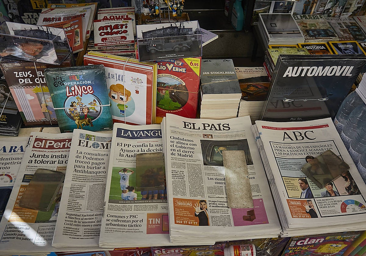 Diferentes periódicos impresos expuestos en un quiosco