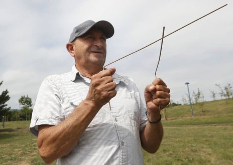 Imagen secundaria 1 - Arriba, Sergio Ávila, que trabaja en una bodega en Valladolid, se sirve de un péndulo para determinar la profundidad de la corriente de agua. Abajo, Manuel con unas varillas de madera junto a una ilustración de la obra de Pierre Le Brun, 'Historia crítica de las prácticas supersticiosas' de 1732