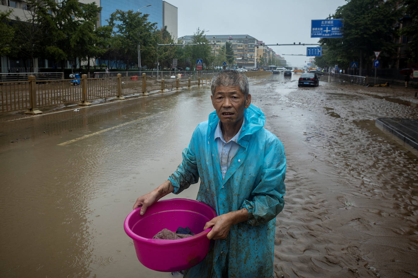 Un hombre en una calle inundada en Pekín debido al tifón Doksuri