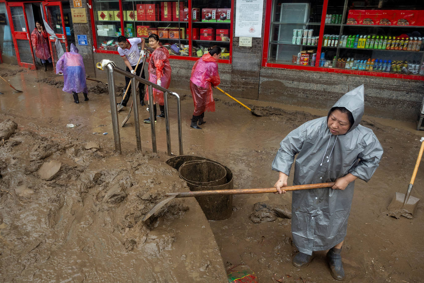 Trabajadores en una calle inundada en Pekín debido al tifón Doksuri