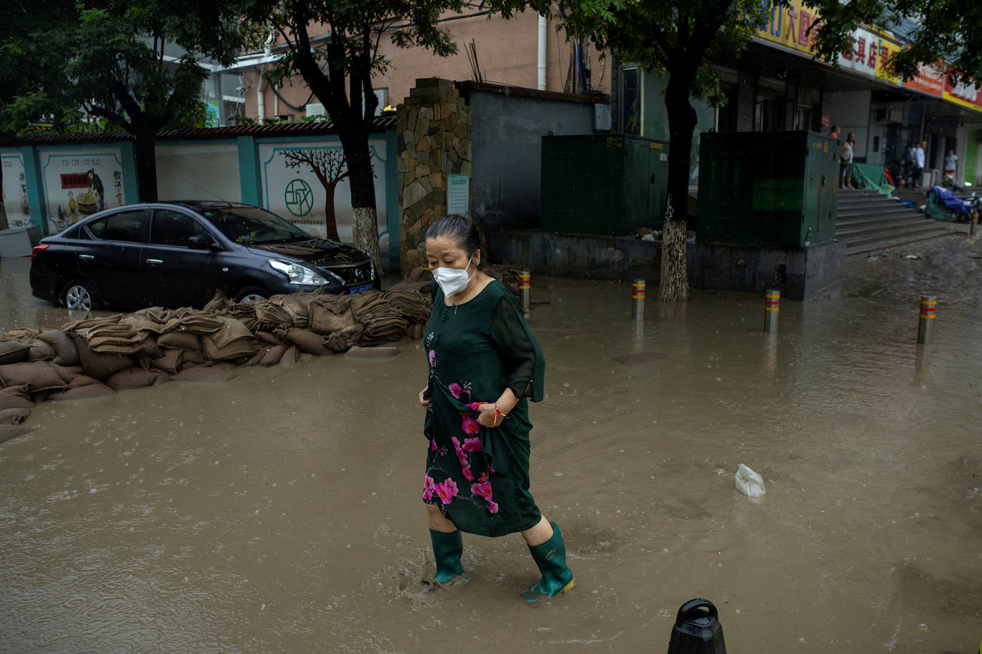 Una mujer por las calles inundadas de Pekín debido al tifón Doksuri
