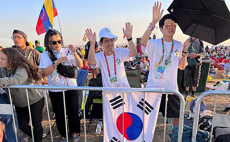 Imagen principal - Arriba, unos jóvenes coreanos reciben con alborozo la designación de Seúl como nueva sede para la Jornada Mundial de la Juventud. Debajo a la izquierda, un grupo de sacerdotes coreanos se preparan para celebrar la eucaristía. A la derecha, un peregrino acude al evento ataviado con el traje tradicional coreano.