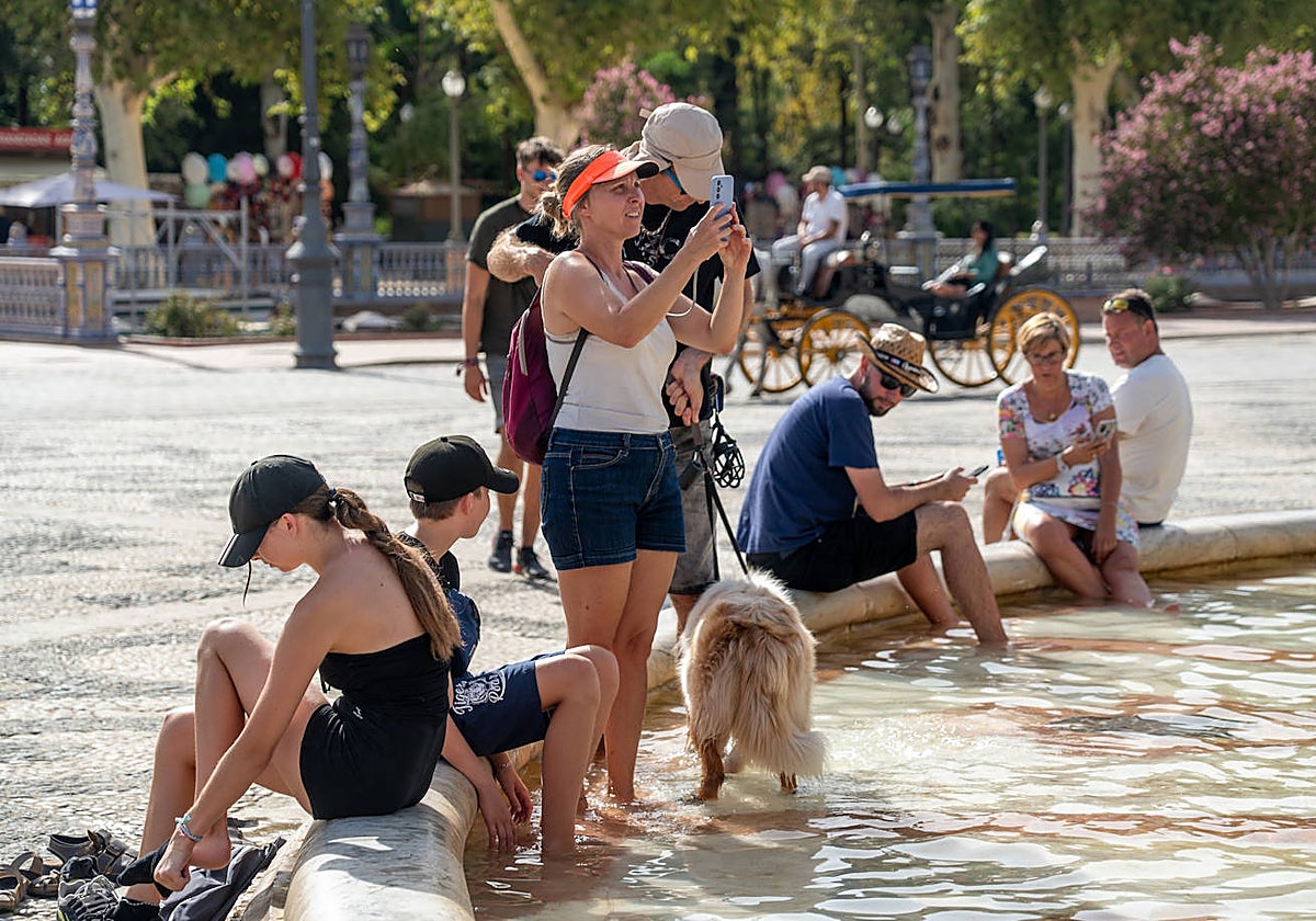 Turistas se refrescan en la fuente de la Plaza de España, Sevilla