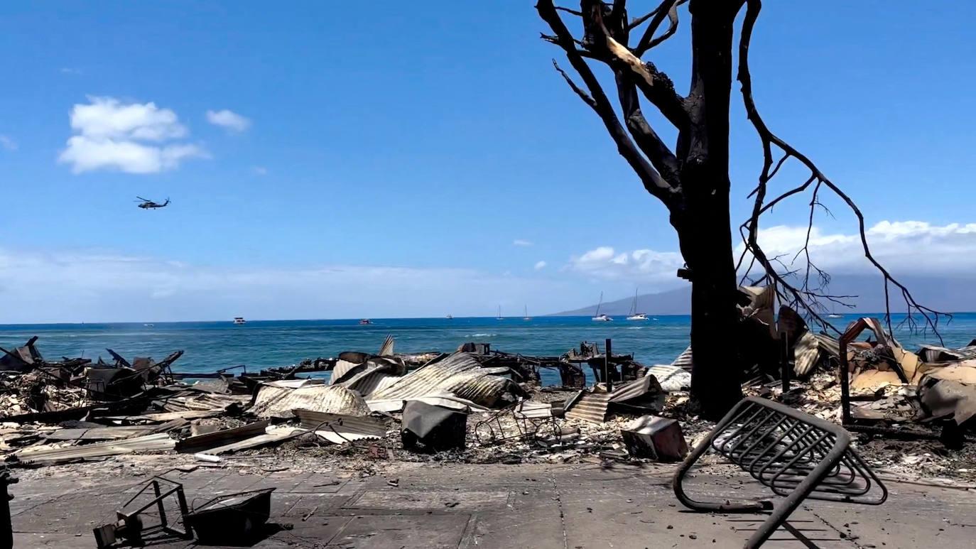 Un helicóptero sobrevuela la destrucción causada por el fuego en Maui