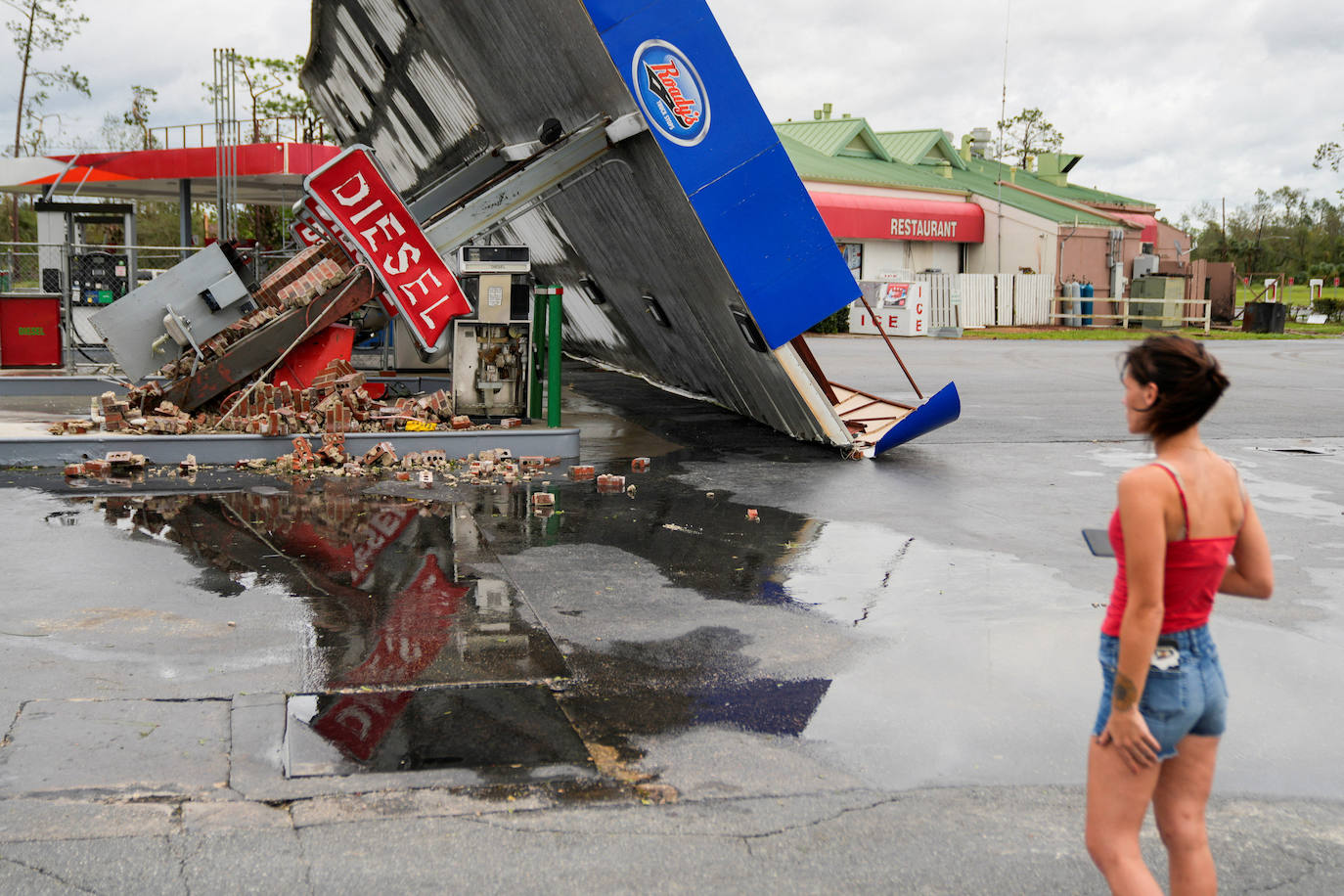 Hope Laird observa los restos de una gasolinera cercana a su casa tras la llegada del huracán Idalia en Perry, Florida