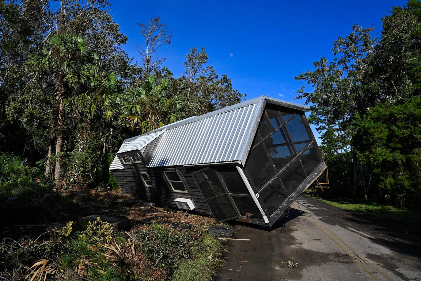 Una casa prefabricada dañada y desplazada en medio de una carretera en Steinhatchee, Florida