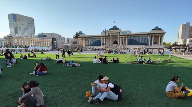 Jóvenes pasan el rato en la plaza Sukhbaatar, frente al parlamento de Mongolia