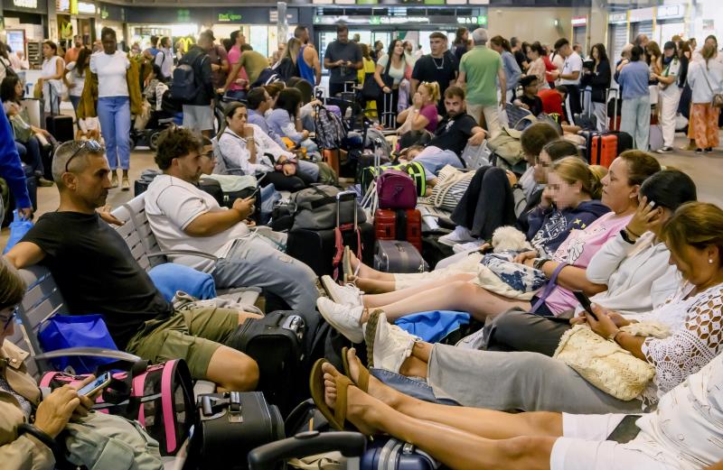 Usuarios de los trenes de Larga y Media distancia de la línea AVE Madrid-Andalucía comprueban los paneles informativos en la estación de Santa Justa, en Sevilla, en la mañana de este lunes