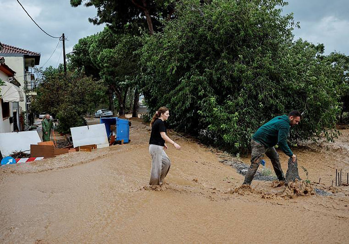 Vecinos intentan proteger su casa de las aguas tras las lluvias torrenciales que destruyeron la infraestructura y provocaron inundaciones, en Agria, Grecia