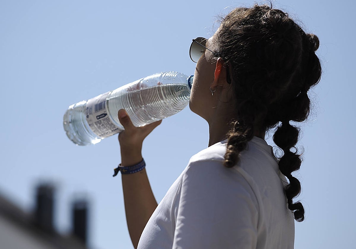 Una joven bebe agua para sofocar las altas temperaturas registradas este verano en Lugo