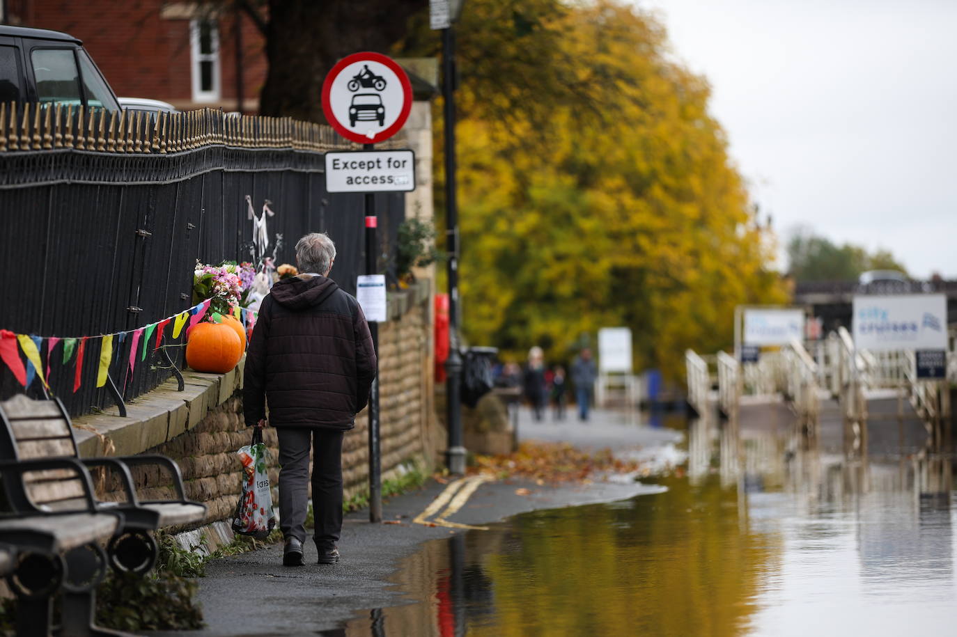 Un señor camina junto a la crecida del río Ouse en York, Gran Bretaña