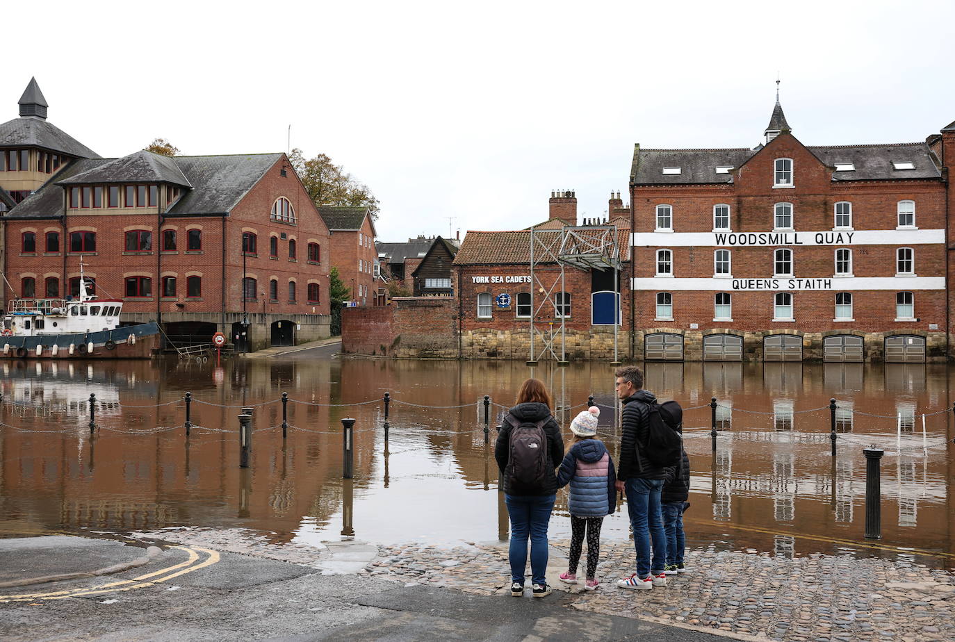 Un grupo de personas observa el agua de las inundaciones del río Ouse en York, Gran Bretaña