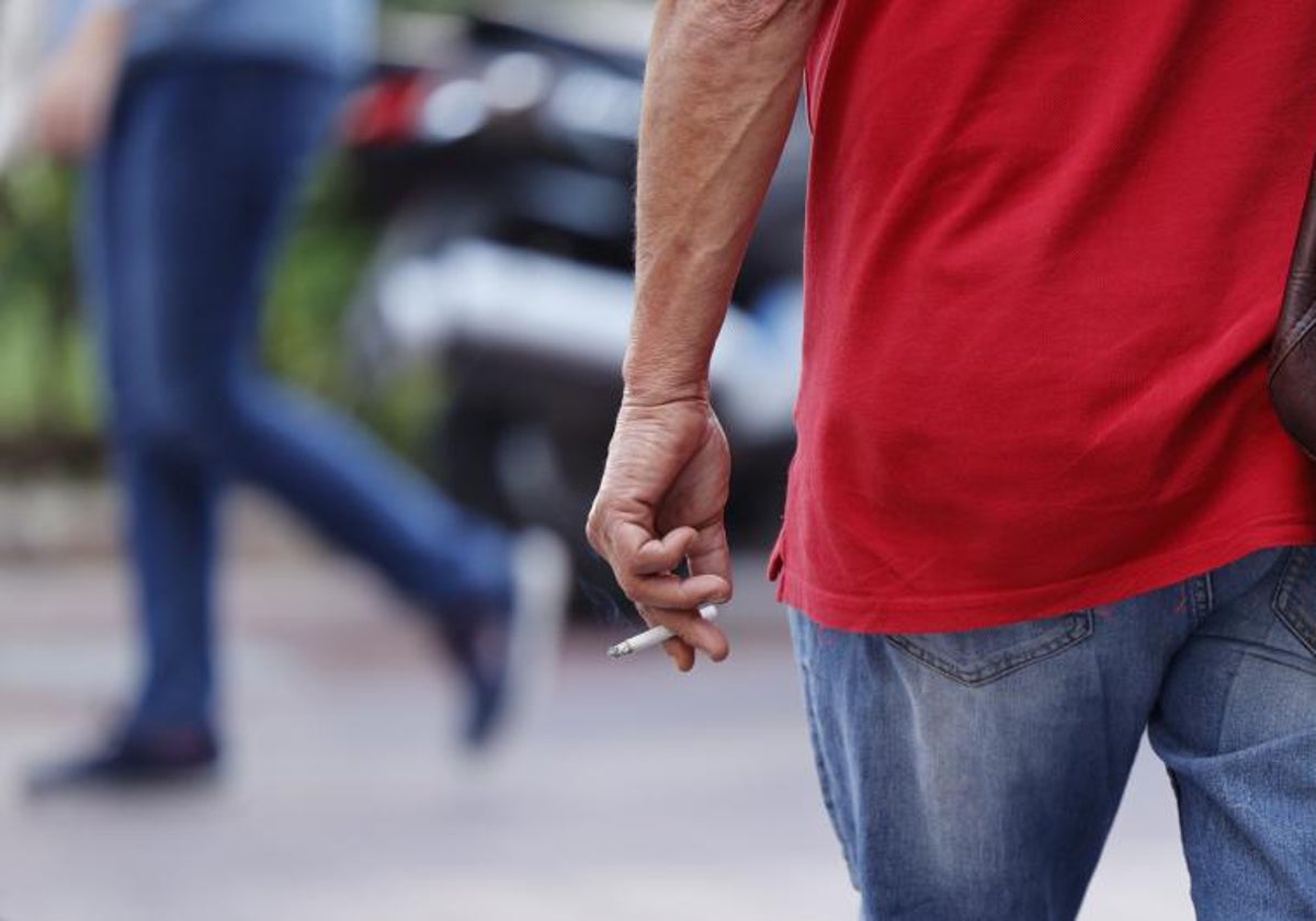 Un hombre fuma un cigarro por la calle