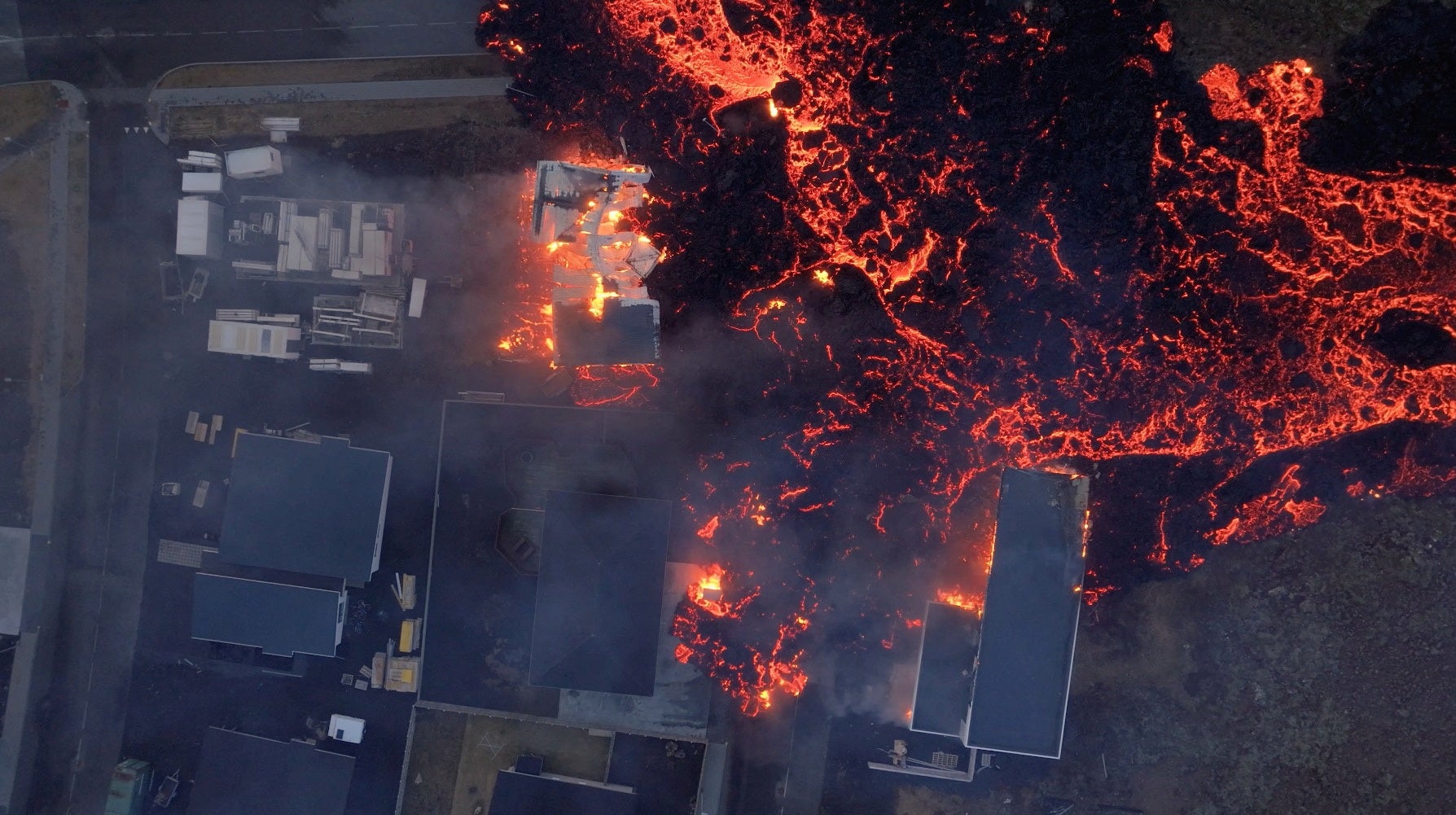 Vista aérea de la lava avanzando hacia unas casas