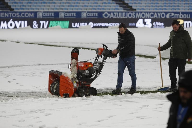 Operarios retiran la nieve de las líneas del terreno de juego del estadio de La Romareda, en Zaragoza