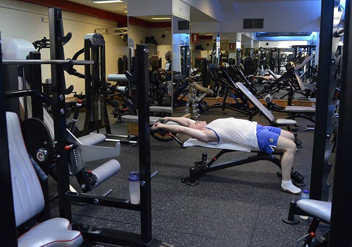 Un hombre hace entrenamientos de fuerza en un gimnasio