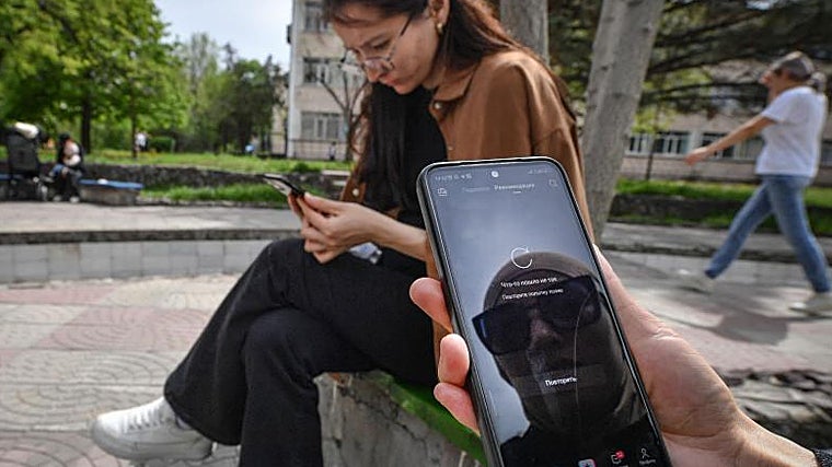 Un mujer muestra la aplicación de TikTok en su