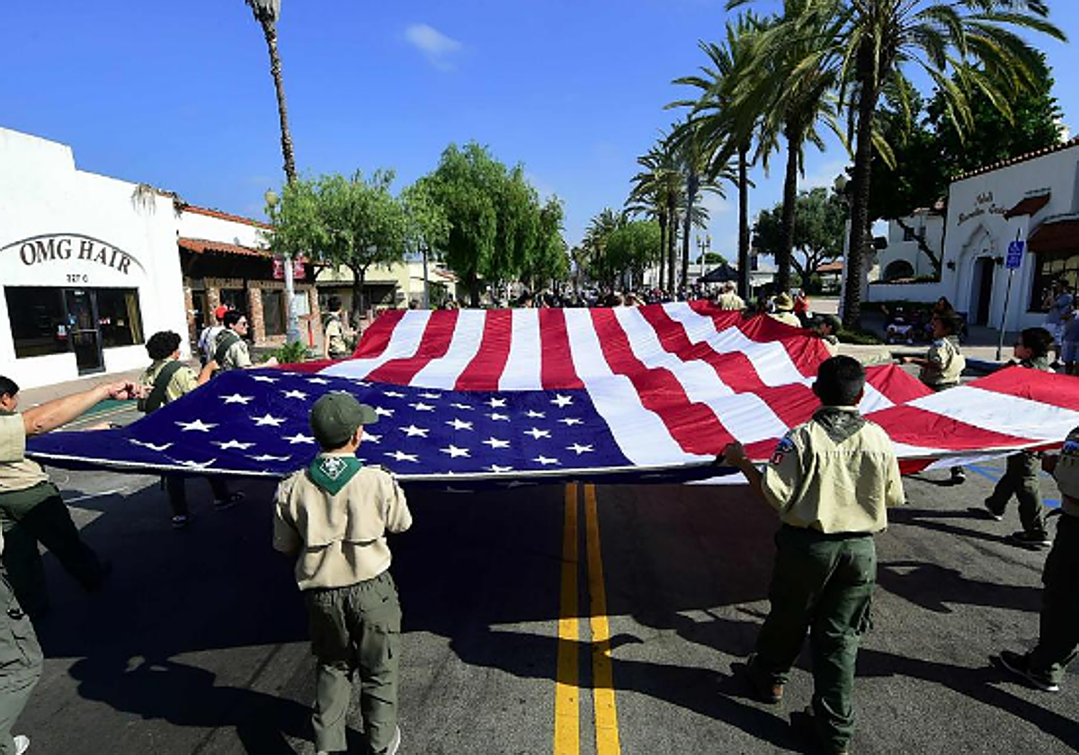 La bandera estadounidense, trasladada por un grupo de menores pertenecientes a los Boy Scouts