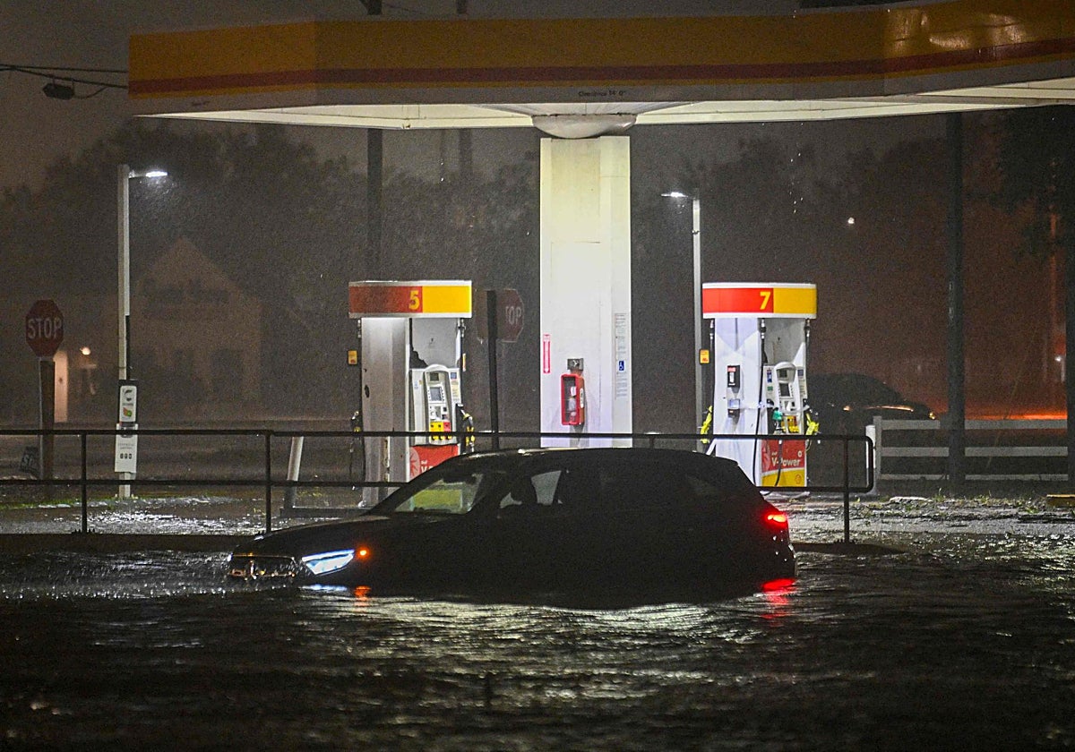 Un coche hundido entre las inundaciones delante de una gasolinera en Florida