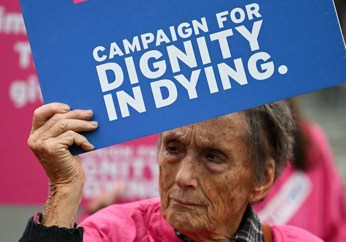 Una activista de «Dignity in Dying» sostiene una pancarta a favor de la eutanasia durante una manifestación frente al Palacio de Westminster, en Londres, ayer