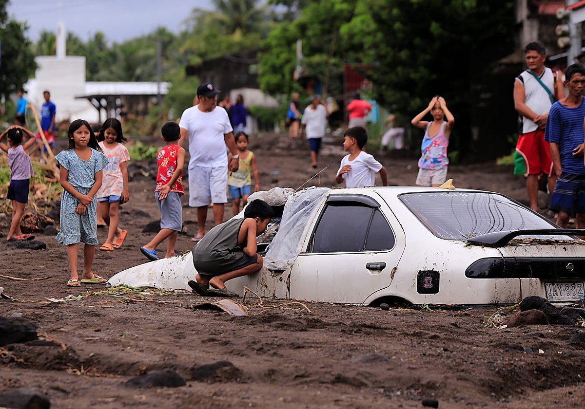 Varios ciudadanos afectados por la tormenta Trami en Guinobatan, al sur de Manila (Filipinas)